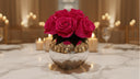 Fuchsia preserved roses in a mercury glass vase on a candlelit marble table