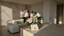 Preserved peony and hydrangea arrangement with a sealed envelope card on a stone table in a sunlit living room