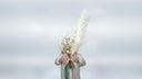 Bouquet of dried pampas grass and gypsophila held against a pale sky