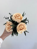 Camille arrangement seen from above, showing three peach preserved roses