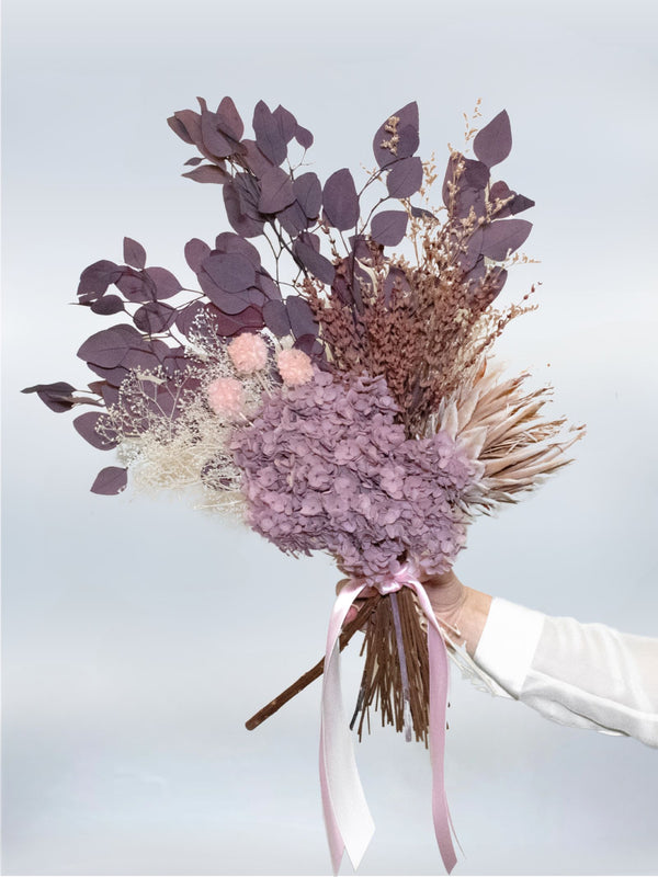 Faye bouquet of mauve preserved hydrangea with lavender eucalyptus, held in one hand