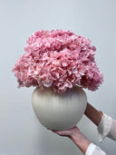 Isla arrangement held in one hand, showing the rounded cream vase