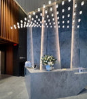 A preserved white floral arrangement on a stone reception desk in a building lobby