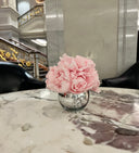 Pink preserved peonies in a silver vase on a marble table at the Lotte New York Palace hotel