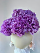 Purple preserved hydrangeas in a round pale ceramic vase