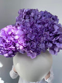Purple preserved hydrangeas in a round white ceramic vase