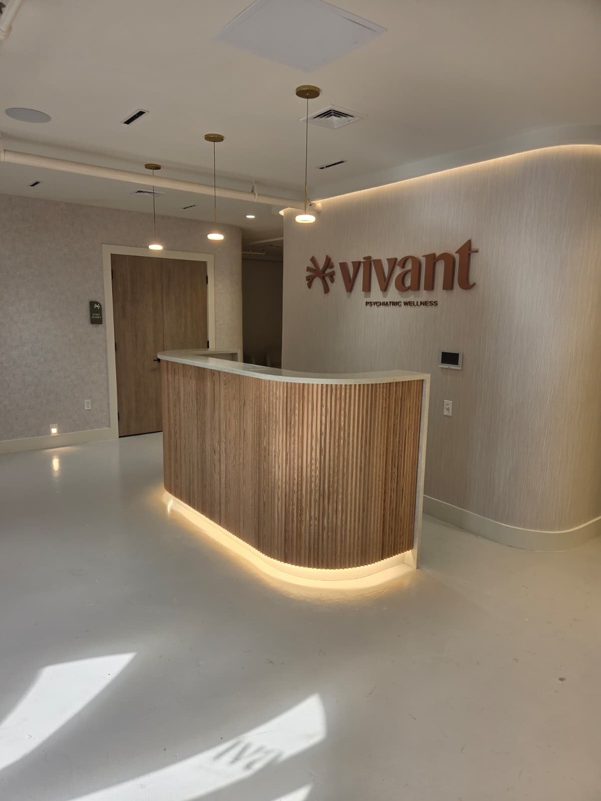 Before: the Vivant Mind reception desk and sign, with no flowers or plants