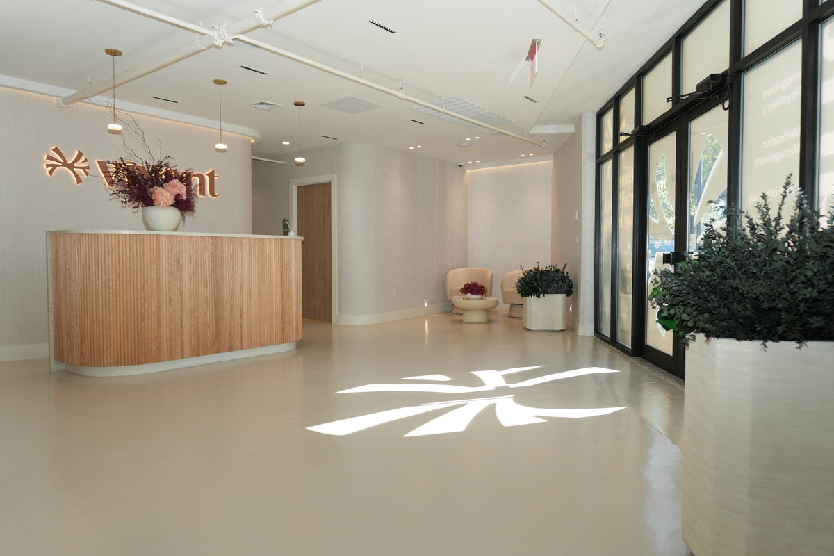 The Vivant Mind reception seen across the lobby, with planters of preserved foliage by the windows