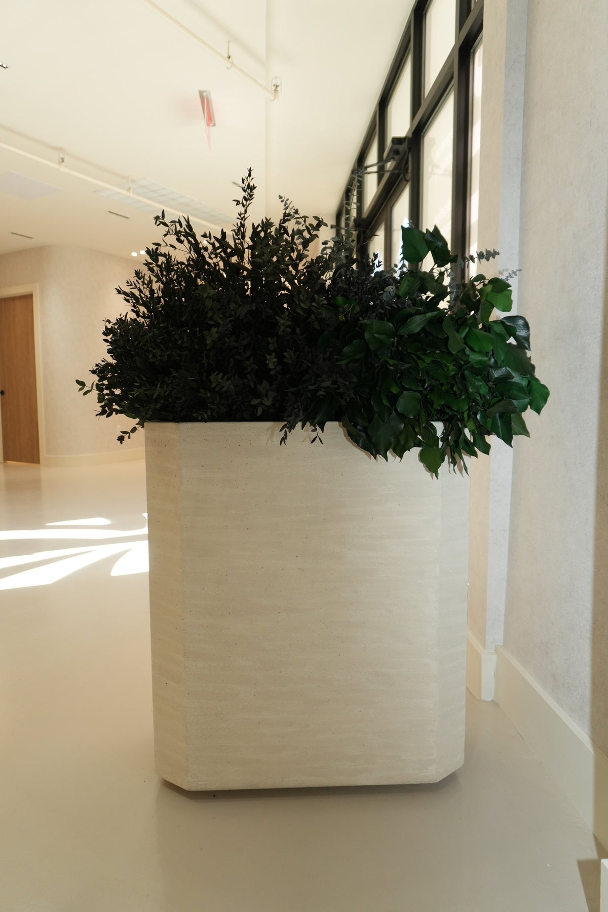 Preserved foliage in a tall textured cream planter at Vivant Mind